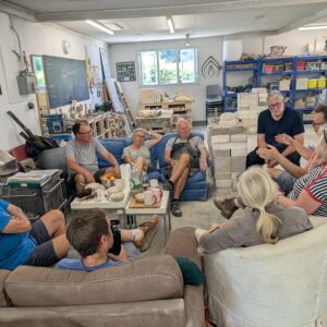 a group of men and women relax on a break from carving stone in the Gray's Stone Carving studio