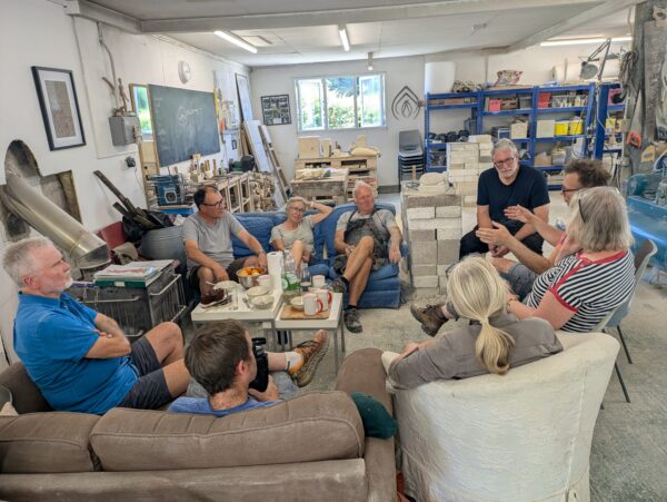 a group of men and women relax on a break from carving stone in the Gray's Stone Carving studio